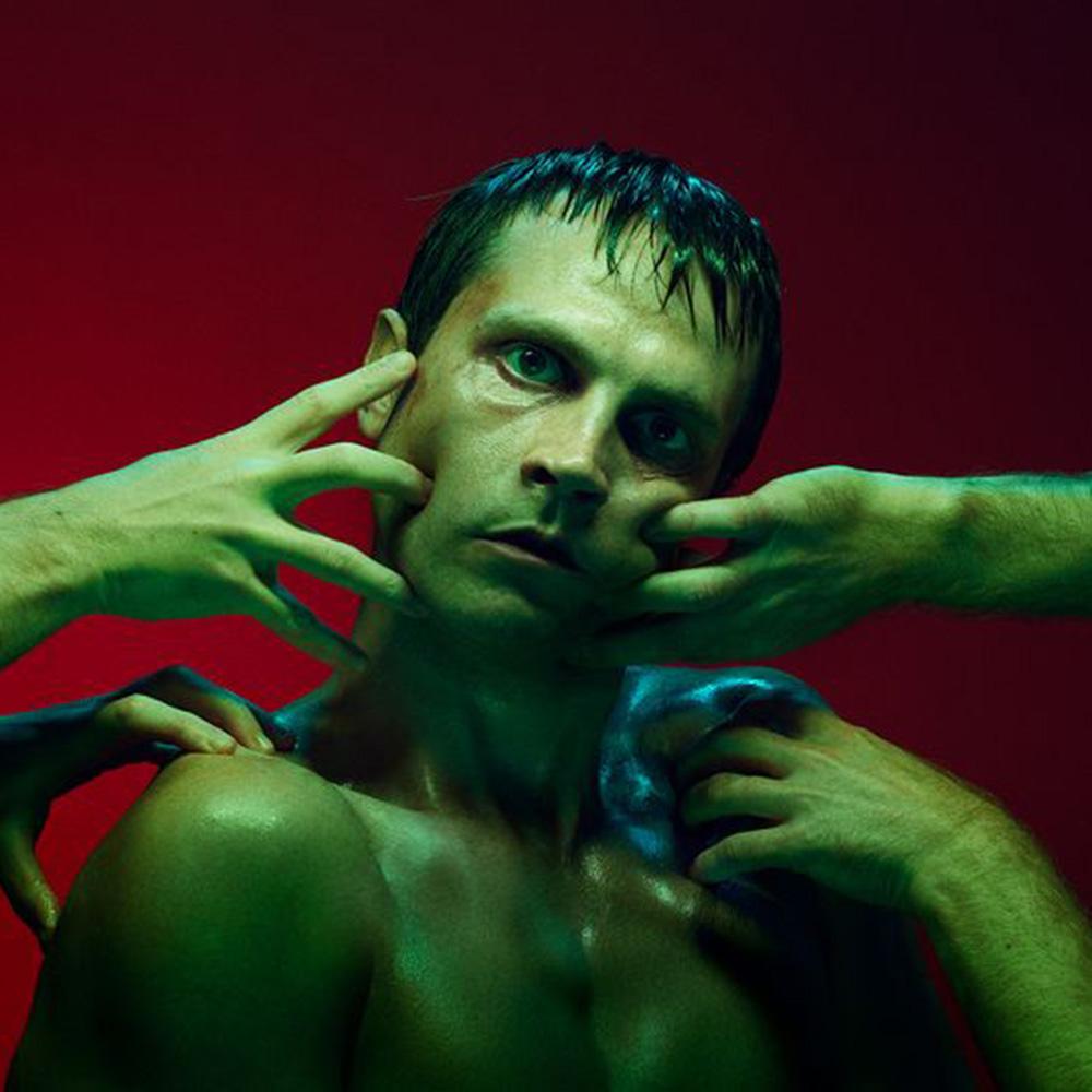 Grön man med gröna händer som rör honom